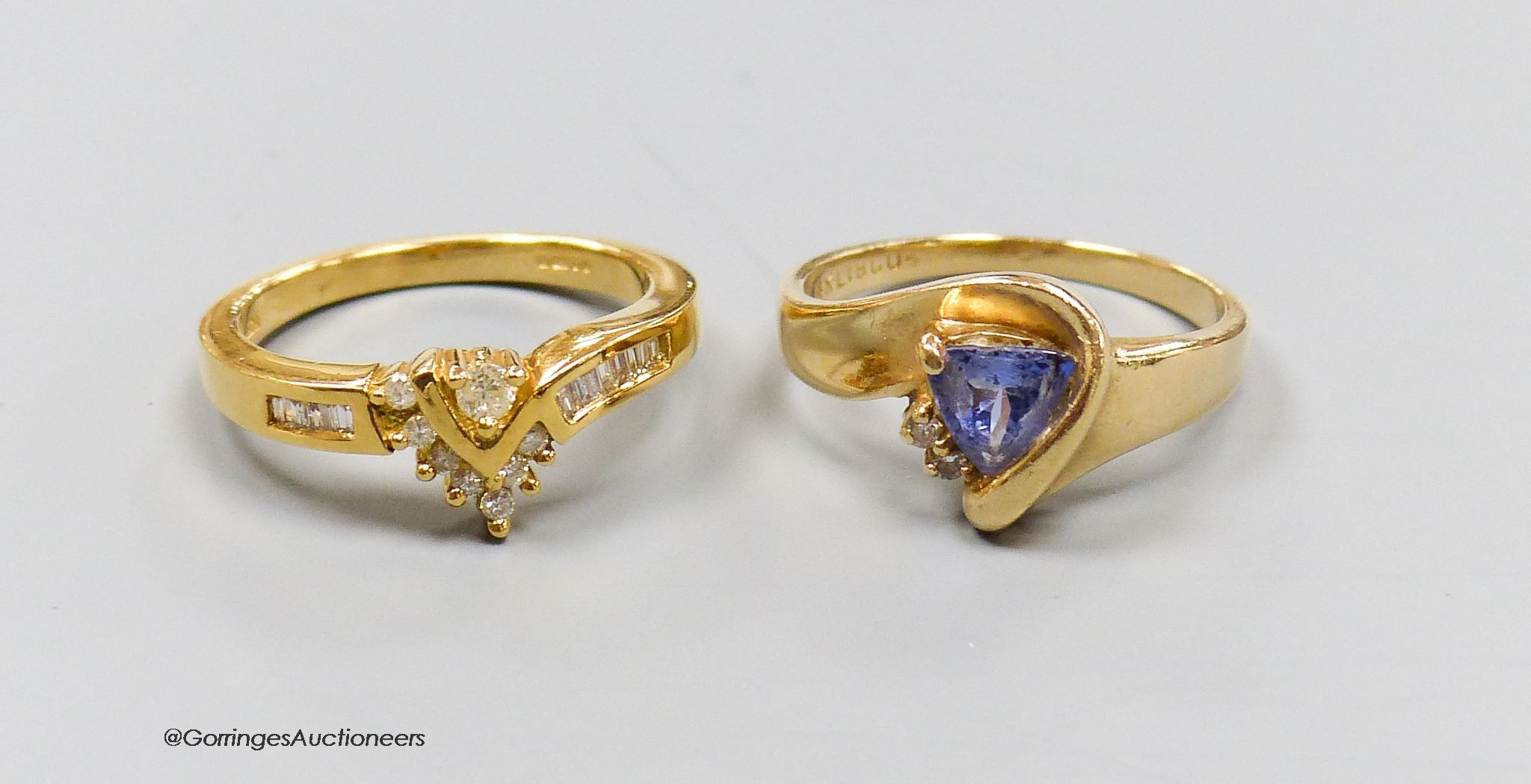 An 18ct gold and diamond dress ring, size N, gross 4.5g, and a 14k gold, diamond and tanzanite ring, size N, gross 3.7g.